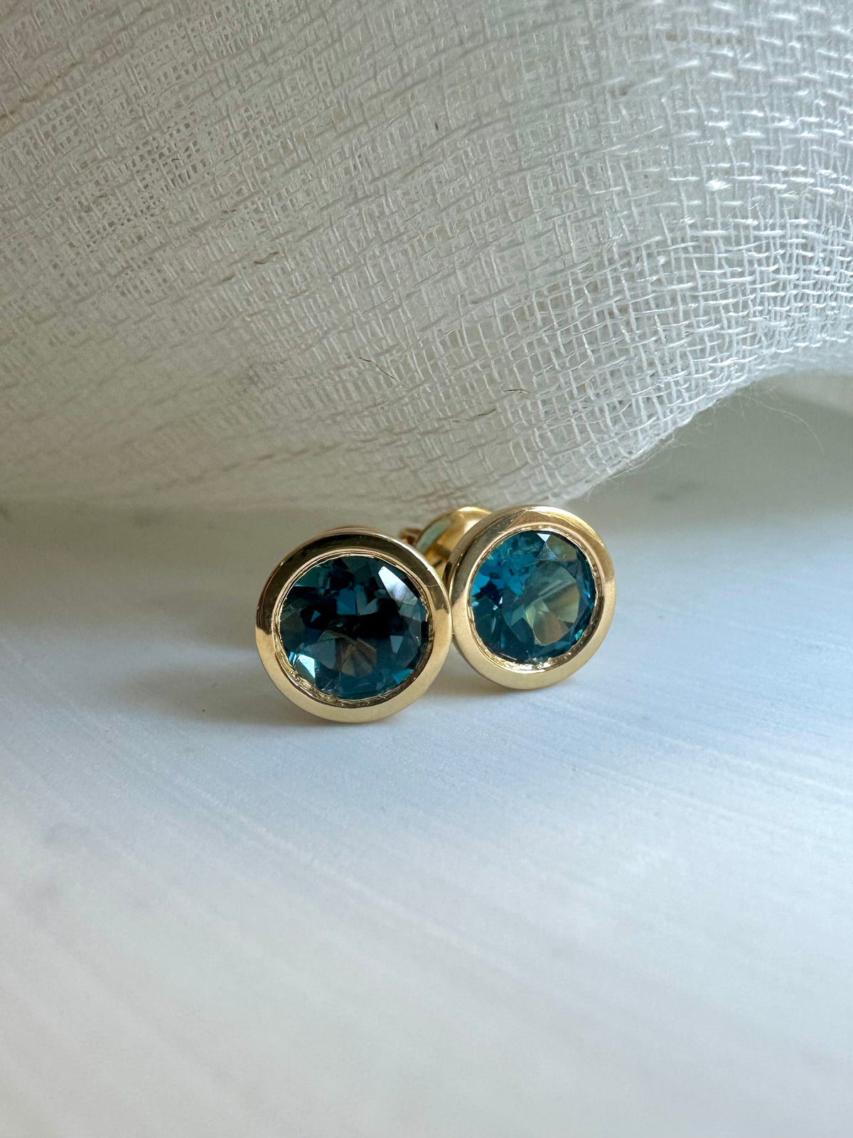 Blue topaz stud earring with a 6mm stone and a 7.5mm round stud