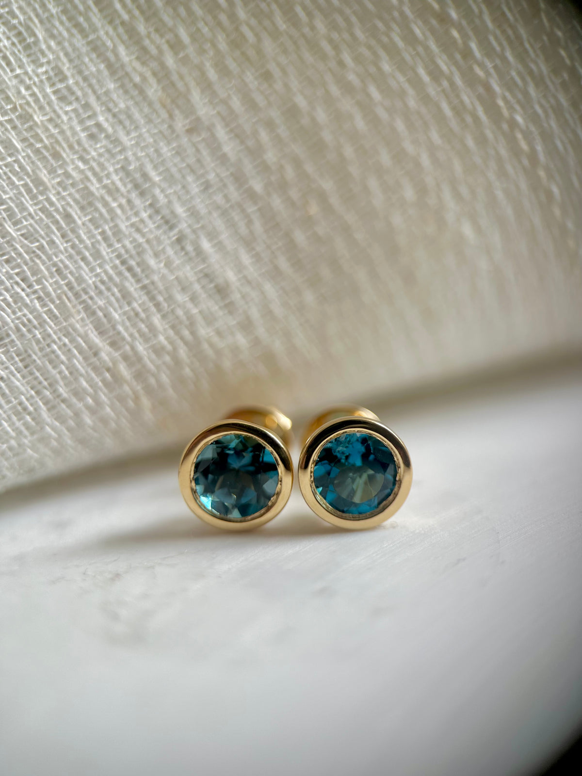 Round London blue topaz stud earrings in a thick 18K yellow gold bezel | Yasmin Nabulsi Fine Jewelry