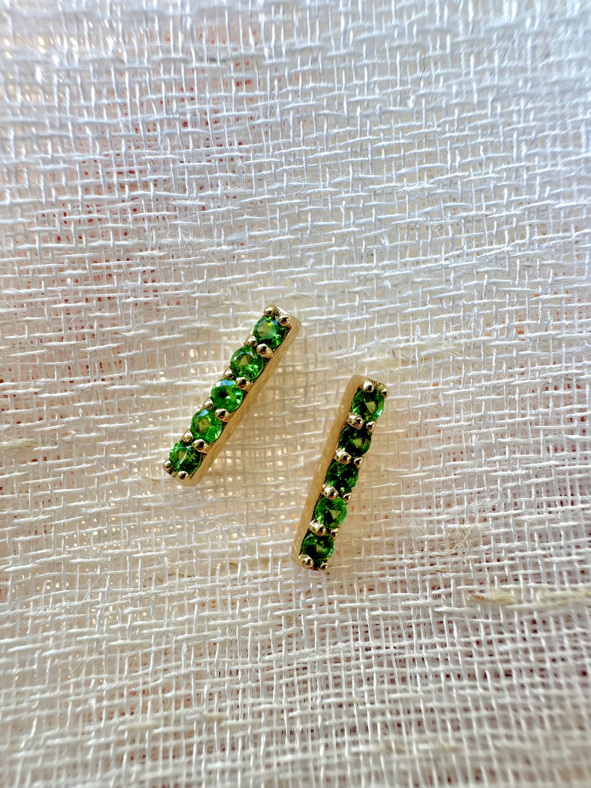 Ten round natural tsavorite gemstones set in a bar stud earring