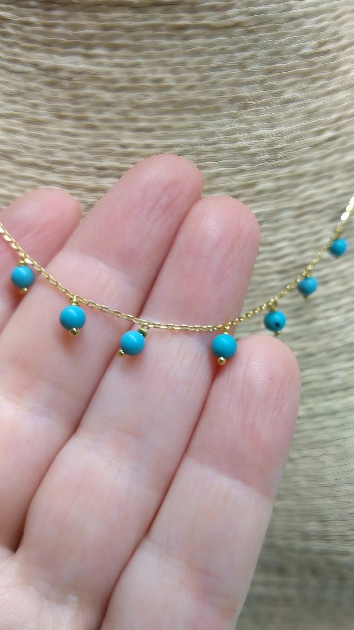 Turquoise choker worn layered with dainty necklaces, 18K gold